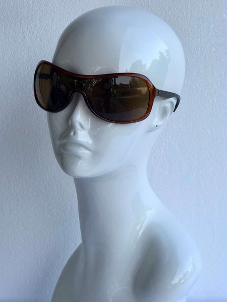 Sleek wraparound sunglasses with brown lenses and a contoured frame. Sporty, chic design for outdoor adventures or casual wear.