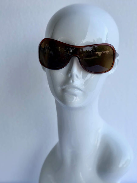 Sleek wraparound sunglasses with brown lenses and contoured frame. Sporty, chic, and perfect for outdoor adventures or casual outings.