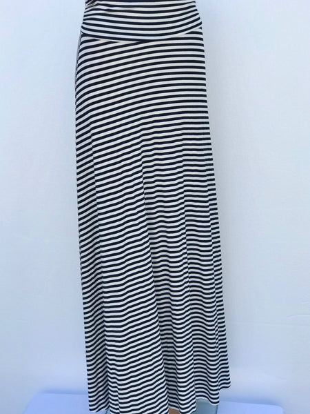 Model wearing Lines of Grace maxi skirt in black and white pattern with fold-over waistband, showing flowy silhouette and elegant drape.