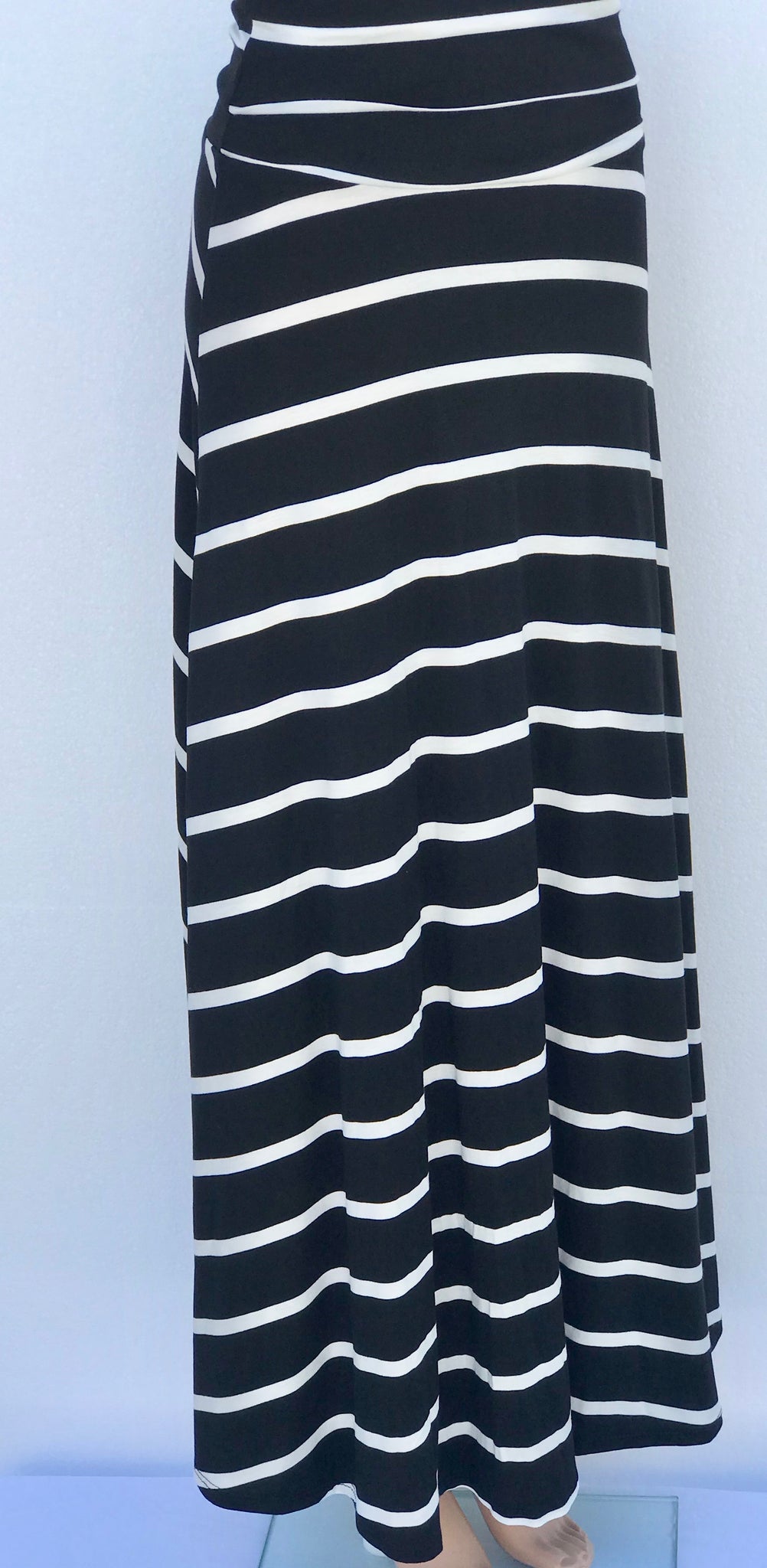 Model wearing Lines of Grace maxi skirt in black and white pattern with fold-over waistband, showing flowy silhouette and elegant drape.