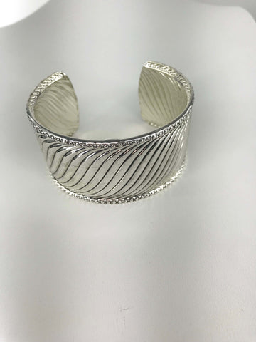 Silver-tone cuff bracelet with twisted wave design, intricate beaded edges, and open-back fit for comfort and elegance