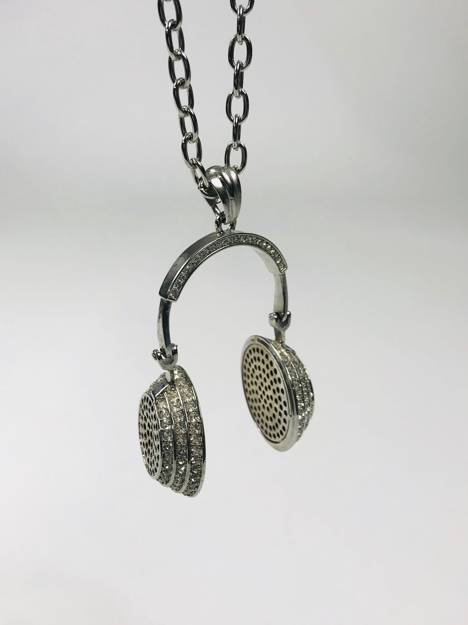 Chic headphone-inspired pendant necklace with a sleek metallic design and sparkling accents, perfect for music lovers and trendsetters.