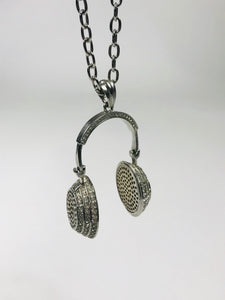 Chic headphone-inspired pendant necklace with a sleek metallic design and sparkling accents, perfect for music lovers and trendsetters.
