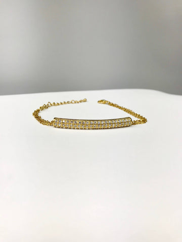 Gold-tone bracelet with curved bar centerpiece, cubic zirconia stones, double-chain, and adjustable clasp for elegant style.