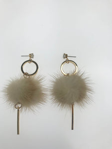 Chic drop earrings with fluffy beige faux fur pom-poms, gold-tone hoops, sleek bar accents, and stud closures featuring sparkling crystal embellishments.