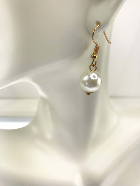 Elegant gold hook earring featuring a luminous white pearl drop. The pearl's reflective sheen and the gold's polished finish are highlighted against a minimalistic white mannequin display, ensuring the earring's sophistication is the focal point.