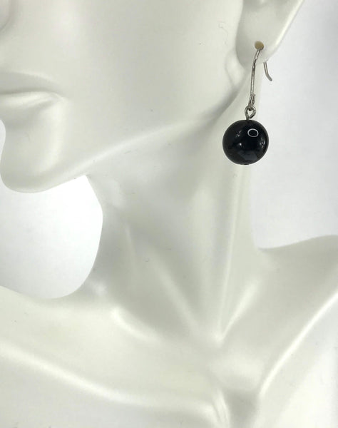 Scratch-resistant black and silver charm necklace with claw-shaped pendant, elephant charm, heart accents, and matching drop earrings.
