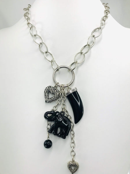 Scratch-resistant black and silver charm necklace with claw-shaped pendant, elephant charm, heart accents, and matching drop earrings.