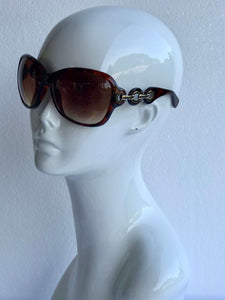 Oversized sunglasses with tortoiseshell or white frames, gold or silver links, and UV protection. Perfect for casual or formal looks.