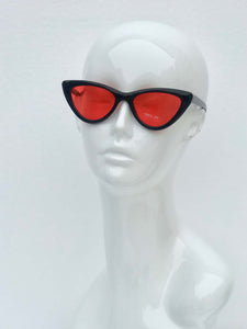Bold cat-eye sunglasses with striking red lenses and sleek black frames. Stylish, comfortable, and perfect for any occasion.