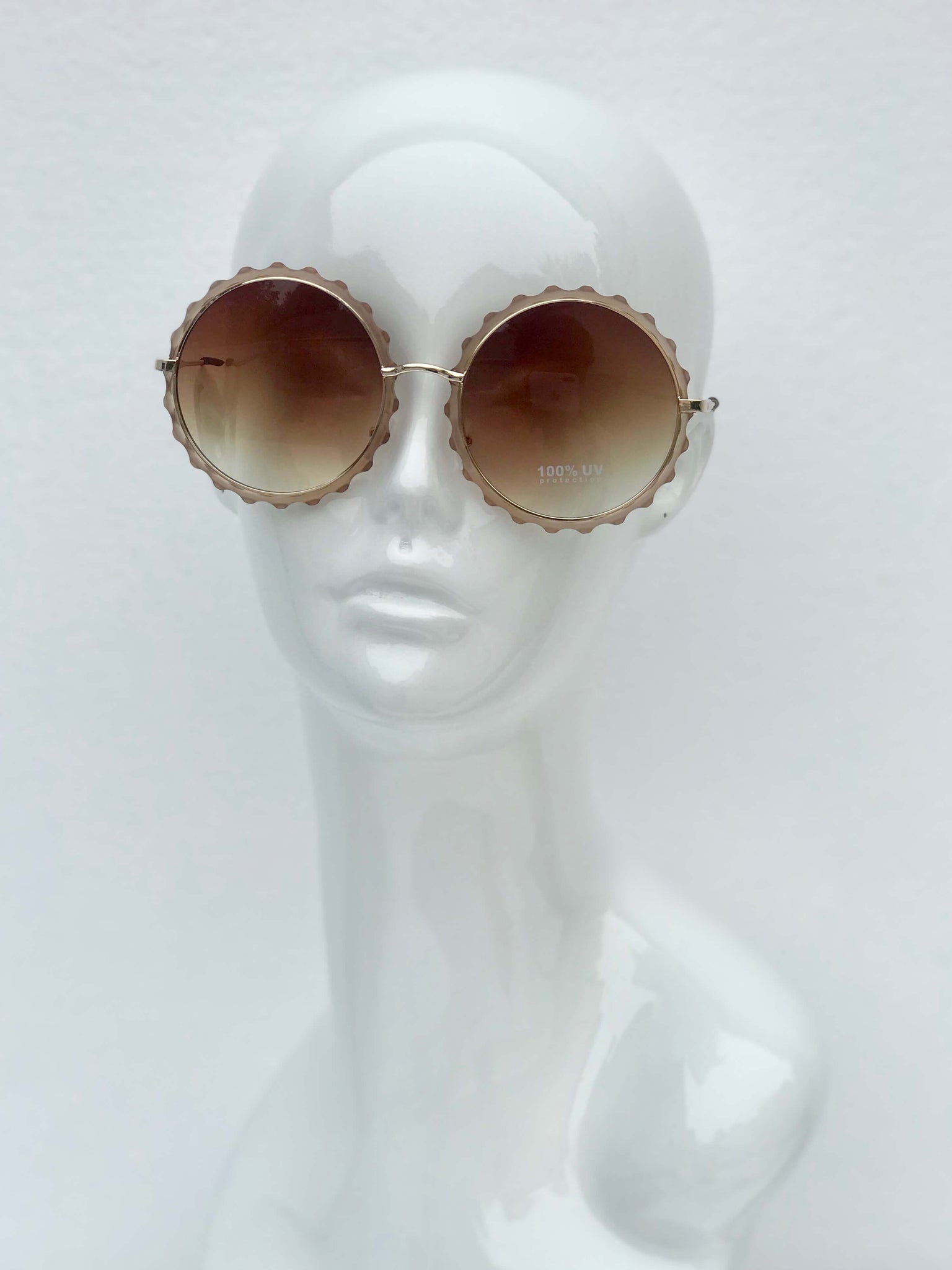 Scalloped round sunglasses with gradient lenses and intricate metal frames. Retro-inspired style with UV protection.