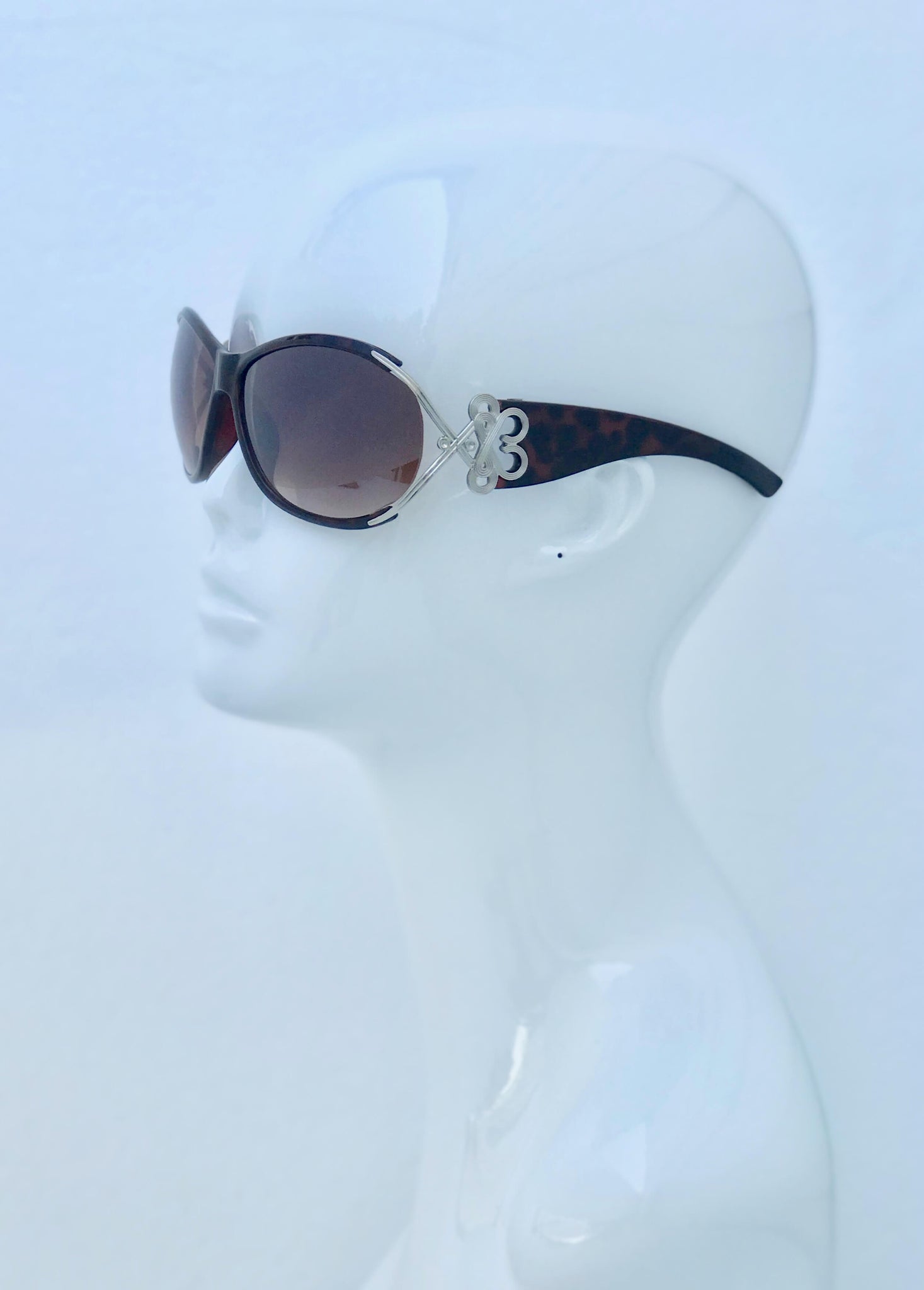 Tortoise shell sunglasses with silver key accents. Lightweight, trendy, and UV-protective for sunny days and unmatched elegance.