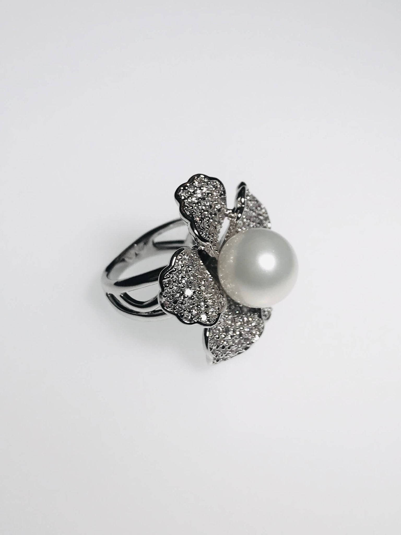 Flower ring with pearl center, diamond petals, and scratch-resistant Ed-Force metal. Perfect blend of elegance & sparkle.