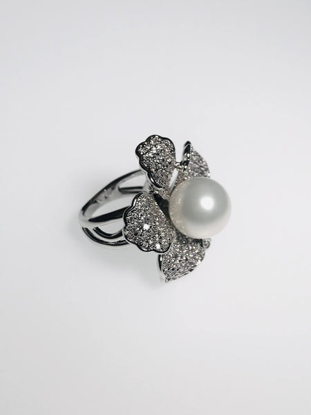 Flower ring with pearl center, diamond petals, and scratch-resistant Ed-Force metal. Perfect blend of elegance & sparkle.