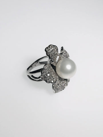 Flower-shaped ring with pearl centerpiece, diamond petals, and scratch-resistant Ed-Force metal. Perfect blend of elegance & sparkle.