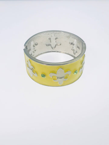 Yellow enamel cuff bracelet with silver-tone fleur-de-lis accents and green rhinestones.