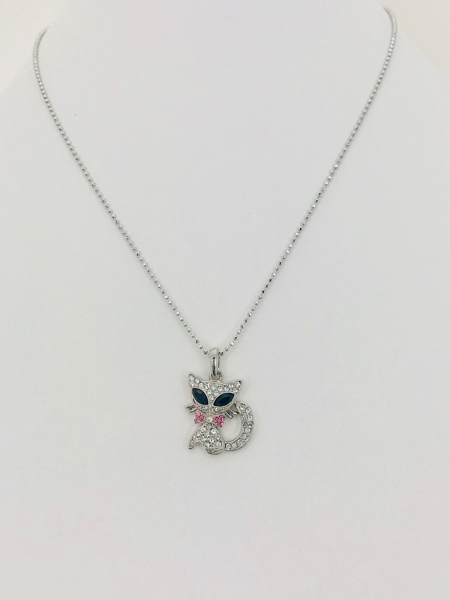Crystal cat pendant necklace with rhinestones, pink bow, and scratch-resistant design. Stylish and perfect for cat lovers.