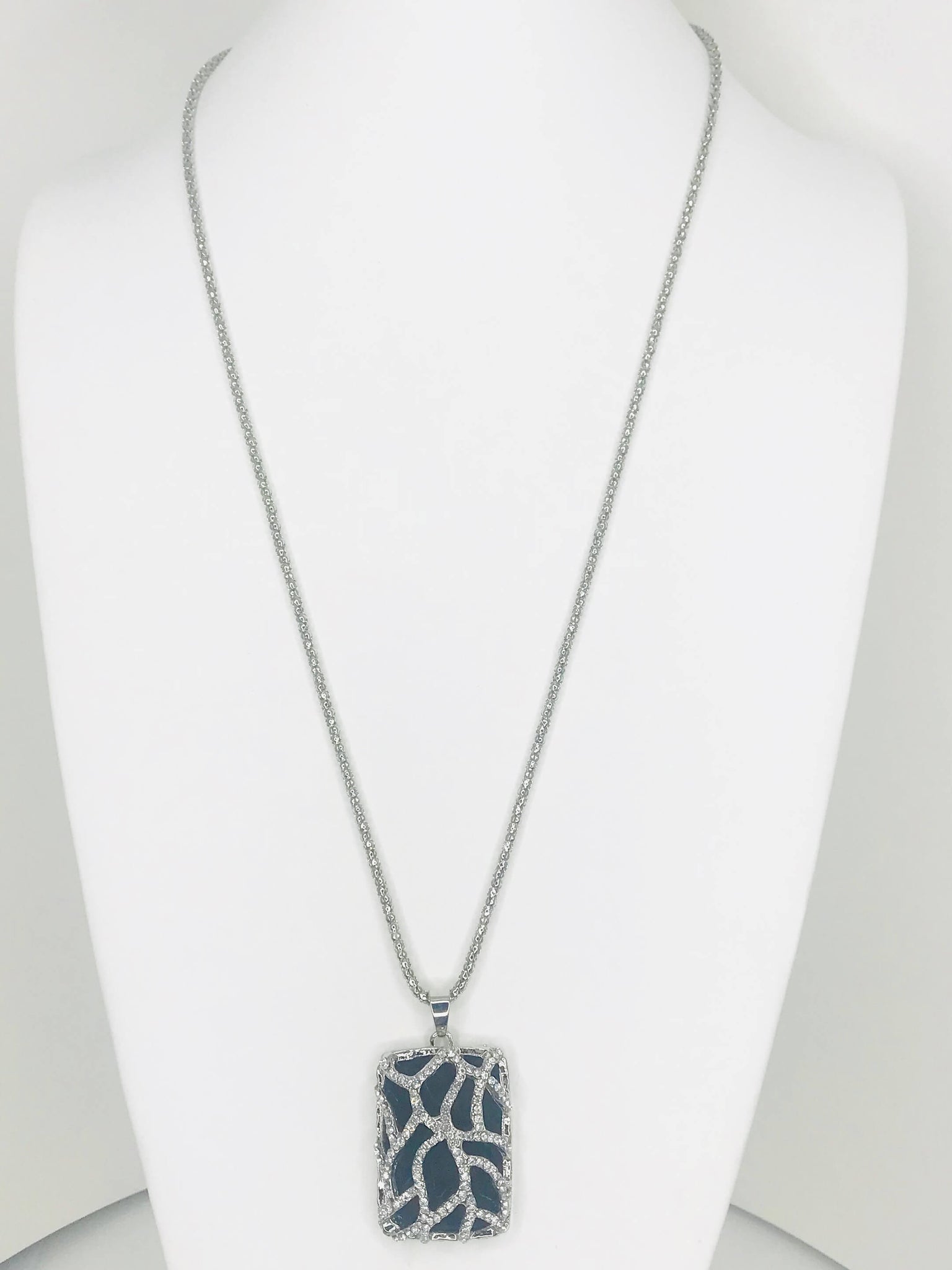 Necklace with pendant featuring silver vine design, sparkling accents, and dark background for elegant and dramatic style.